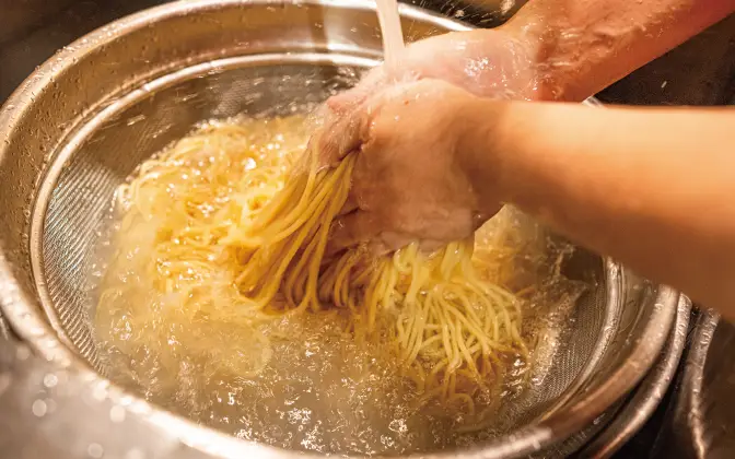茹でた麺を冷水で締めている様子